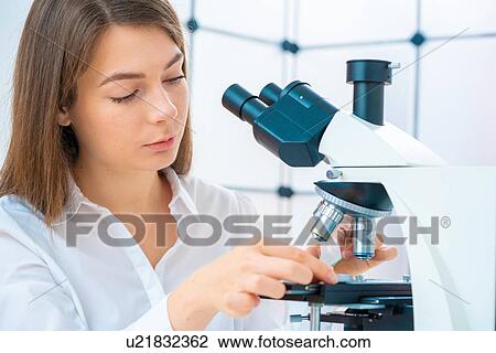 Stock Image - Researcher using microscope.. Fotosearch