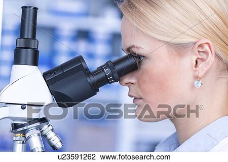 Stock Image - Researcher using microscope.. Fotosearch