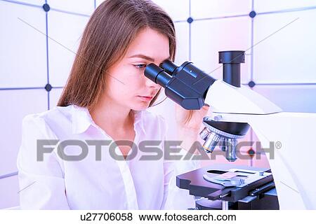 Stock Photo - Researcher using microscope.. Fotosearch