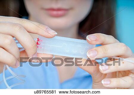 Stock Image - Researcher with lab on a chip.. Fotosearch