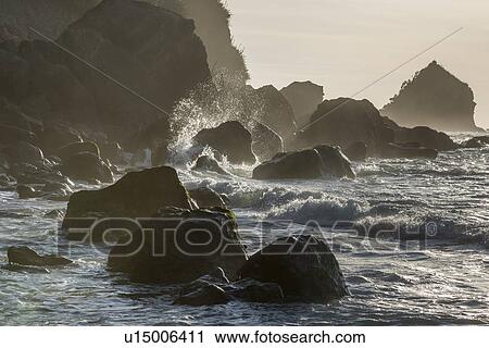 Stock Image - Rocks on beach at sunset in Barrytown, New Zealand. Fotosearch