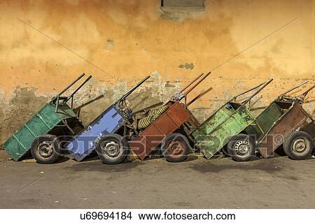 Picture - Row of carts against weathered wall. Fotosearch