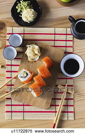 Salmon sushi on cutting board with condiments View Large Photo Image Stock Photography - Salmon sushi on cutting board with condiments. Fotosearch