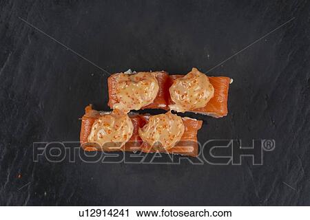 Stock Image - Salmon sushi with orange sauce. Fotosearch