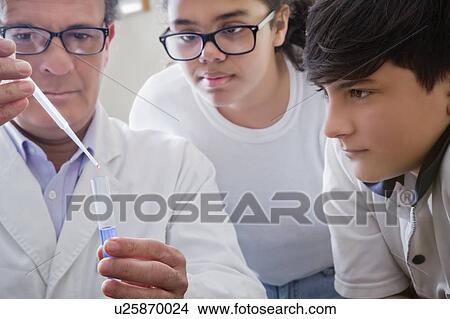 Science teacher showing students test tube experiment View Large Photo Image Picture - Science teacher showing students test tube experiment. Fotosearch