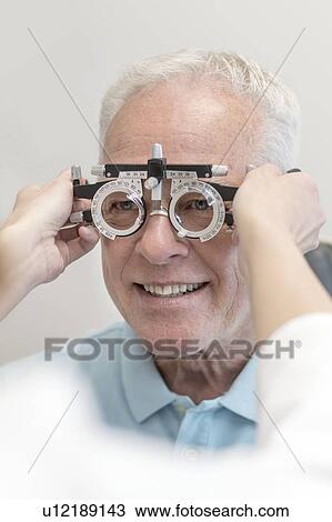 Senior man having his eyes tested. View Large Photo Image Stock Image - Senior man having his eyes tested.. Fotosearch
