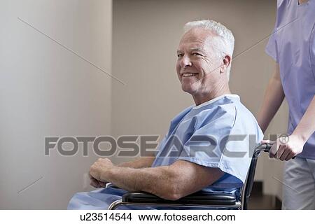 Senior man in hospital gown in wheelchair, smiling. View Large Photo Image Picture - Senior man in hospital gown in wheelchair, smiling.. Fotosearch