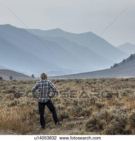 Senior man standing in field by mountains in Sun Valley, Idaho, USA View Large Photo Image Stock Image - Senior man standing in field by mountains in Sun Valley, Idaho, USA. Fotosearch