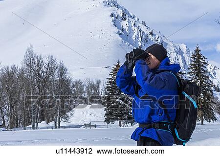 Senior man using binoculars by snow covered mountain in Sun Valley, Idaho, USA View Large Photo Image Stock Image - Senior man using binoculars by snow covered mountain in Sun Valley, Idaho, USA. Fotosearch