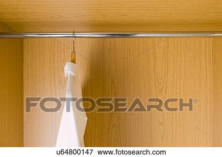 Stock Photo - Shirts on clothes hangers in wardrobe. Fotosearch