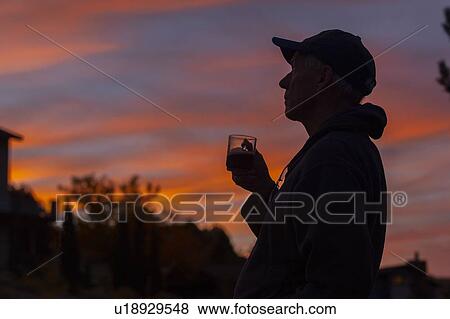 Silhouette of man holding coffee cup at sunset View Large Photo Image Stock Photo - Silhouette of man holding coffee cup at sunset. Fotosearch