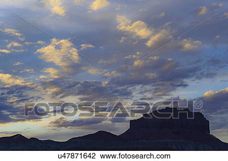 Stock Image - Silhouette of rock formations under clouds at sunset in Goblin Valley State Park, Utah, USA. Fotosearch
