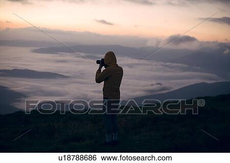 Silhouette of young man taking photographs at sunset in the Carpathian Mountain Range View Large Photo Image Stock Photograph - Silhouette of young man taking photographs at sunset in the Carpathian Mountain Range. Fotosearch