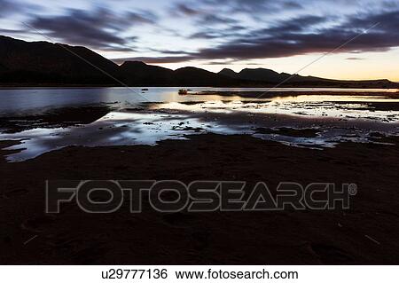 Stock Photograph - Silhouetted mountain ranges on horizon over water, Cape Town, Western Cape, South Africa. Fotosearch