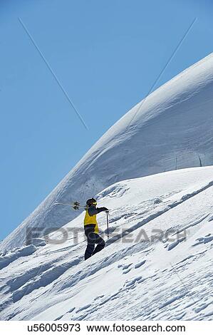 Stock Image - Skier walking up mountain, Saas-Fee, Valais, Switzerland. Fotosearch