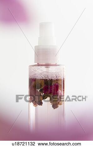 Stock Image - Skin care spray bottle with flowers inside. Fotosearch