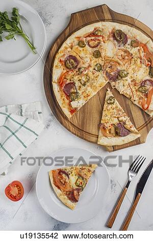 Stock Image - Sliced pizza with jalapenos. Fotosearch