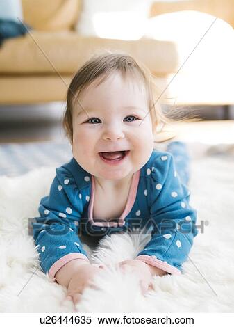 Smiling baby girl lying on rug View Large Photo Image Stock Photography - Smiling baby girl lying on rug. Fotosearch