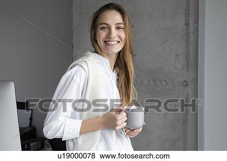 Stock Photo - Smiling businesswoman with coffee cup. Fotosearch