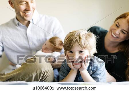 Smiling family on bed View Large Photo Image Stock Photography - Smiling family on bed. Fotosearch