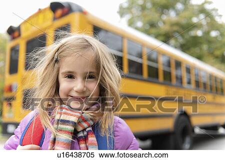 Stock Photography - Smiling girl by school bus. Fotosearch
