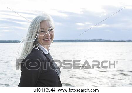 Picture - Smiling mature woman by Potomac River in Washington DC, USA. Fotosearch