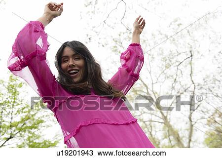 Smiling woman dancing in pink dress View Large Photo Image Stock Image - Smiling woman dancing in pink dress. Fotosearch