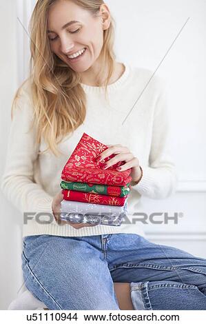 Smiling woman holding Christmas fabrics View Large Photo Image Picture - Smiling woman holding Christmas fabrics. Fotosearch