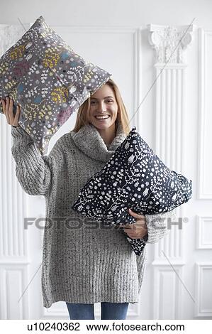 Smiling woman holding patterned cushions View Large Photo Image Stock Image - Smiling woman holding patterned cushions. Fotosearch