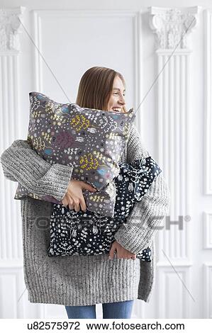 Smiling woman holding patterned cushions View Large Photo Image Stock Image - Smiling woman holding patterned cushions. Fotosearch