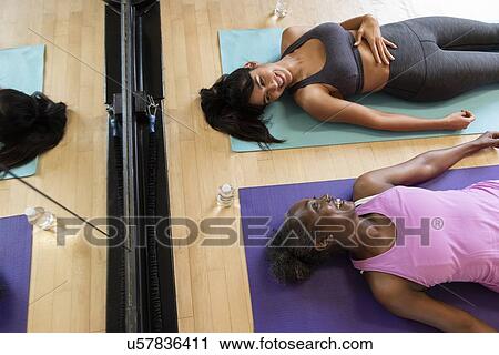 Smiling women lying on yoga mats View Large Photo Image Stock Image - Smiling women lying on yoga mats. Fotosearch