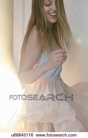 Stock Photograph - Smiling young woman dancing. Fotosearch