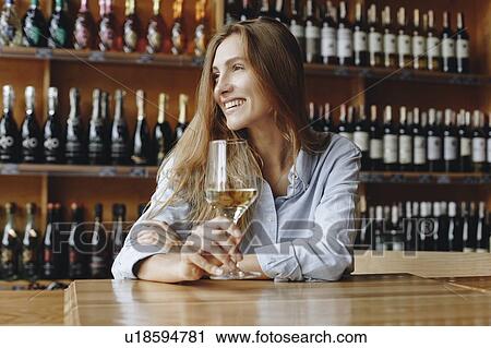 Smiling young woman holding glass of white wine View Large Photo Image Stock Image - Smiling young woman holding glass of white wine. Fotosearch