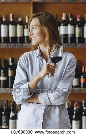 Smiling young woman holding glass of red wine View Large Photo Image Stock Image - Smiling young woman holding glass of red wine. Fotosearch