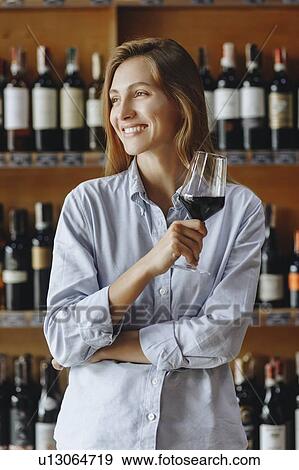 Smiling young woman holding glass of red wine View Large Photo Image Stock Photo - Smiling young woman holding glass of red wine. Fotosearch