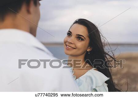 Stock Photography - Smiling young woman looking at her partner. Fotosearch
