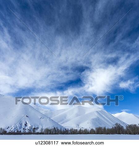 Stock Photo - Snow covered mountains under clouds in Sun Valley, Idaho, USA. Fotosearch