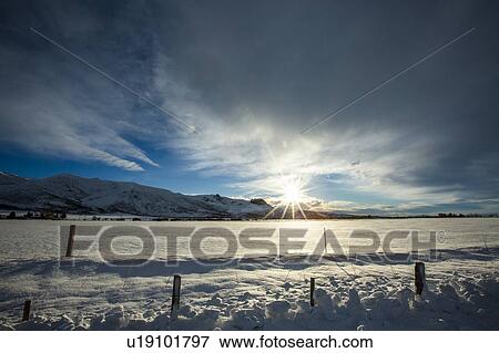 Stock Photo - Snow field and mountain at sunrise in Picabo, Idaho. Fotosearch