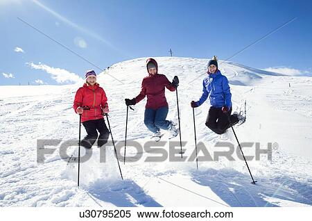 Snowshoer girl and teenage sisters jumping mid air on snow covered mountainside, portrait, Styria, Tyrol, Austria View Large Photo Image Stock Photography - Snowshoer girl and teenage sisters jumping mid air on snow covered mountainside, portrait, Styria, Tyrol, Austria. Fotosearch