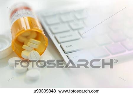 Spilled pill bottle by computer keyboard View Large Photo Image Stock Photo - Spilled pill bottle by computer keyboard. Fotosearch