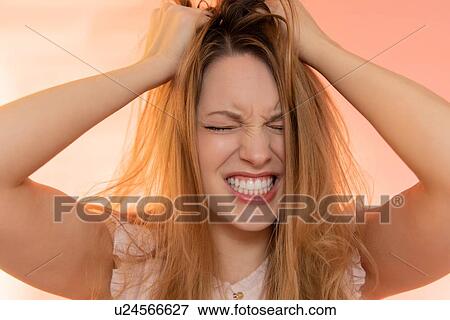 Stock Photo - Stressed young woman with her hands in her hair. Fotosearch