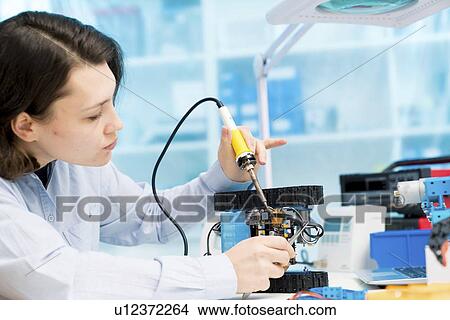 Picture - Student in CNC (computer numerical control) and robotics laboratory, experiment with microcontroller and robot CNC module.. Fotosearch