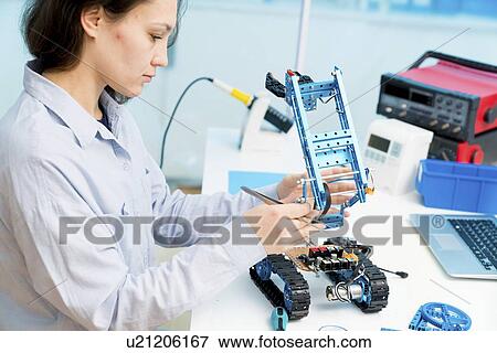 Stock Photo - Student in CNC (computer numerical control) and robotics laboratory, experiment with microcontroller and robot CNC module.. Fotosearch
