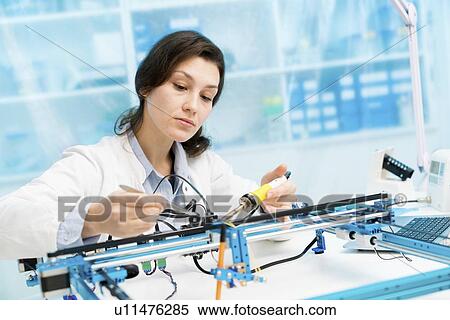 Stock Photography - Student in CNC (computer numerical control) and robotics laboratory, experiment with microcontroller and robot CNC module.. Fotosearch