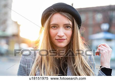 Stock Photography - Stylish young woman with long blond hair on city street, portrait,. Fotosearch