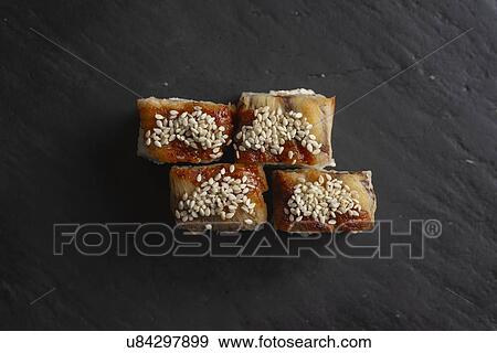 Stock Photo - Sushi with sesame seeds on black surface. Fotosearch