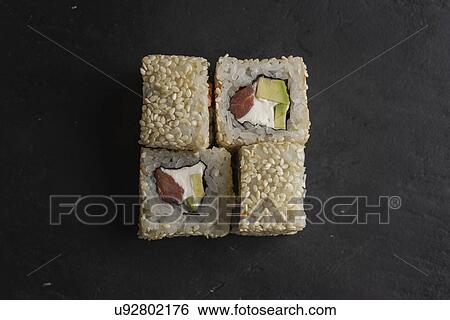 Stock Photograph - Sushi with sesame seeds on black surface. Fotosearch