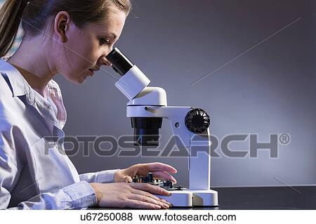 Stock Photo - Technician examining circuit board.. Fotosearch