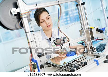Stock Photo - Technician working on 3D printer.. Fotosearch