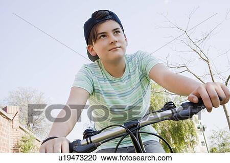 Teenage boy cycling in park View Large Photo Image Stock Image - Teenage boy cycling in park. Fotosearch